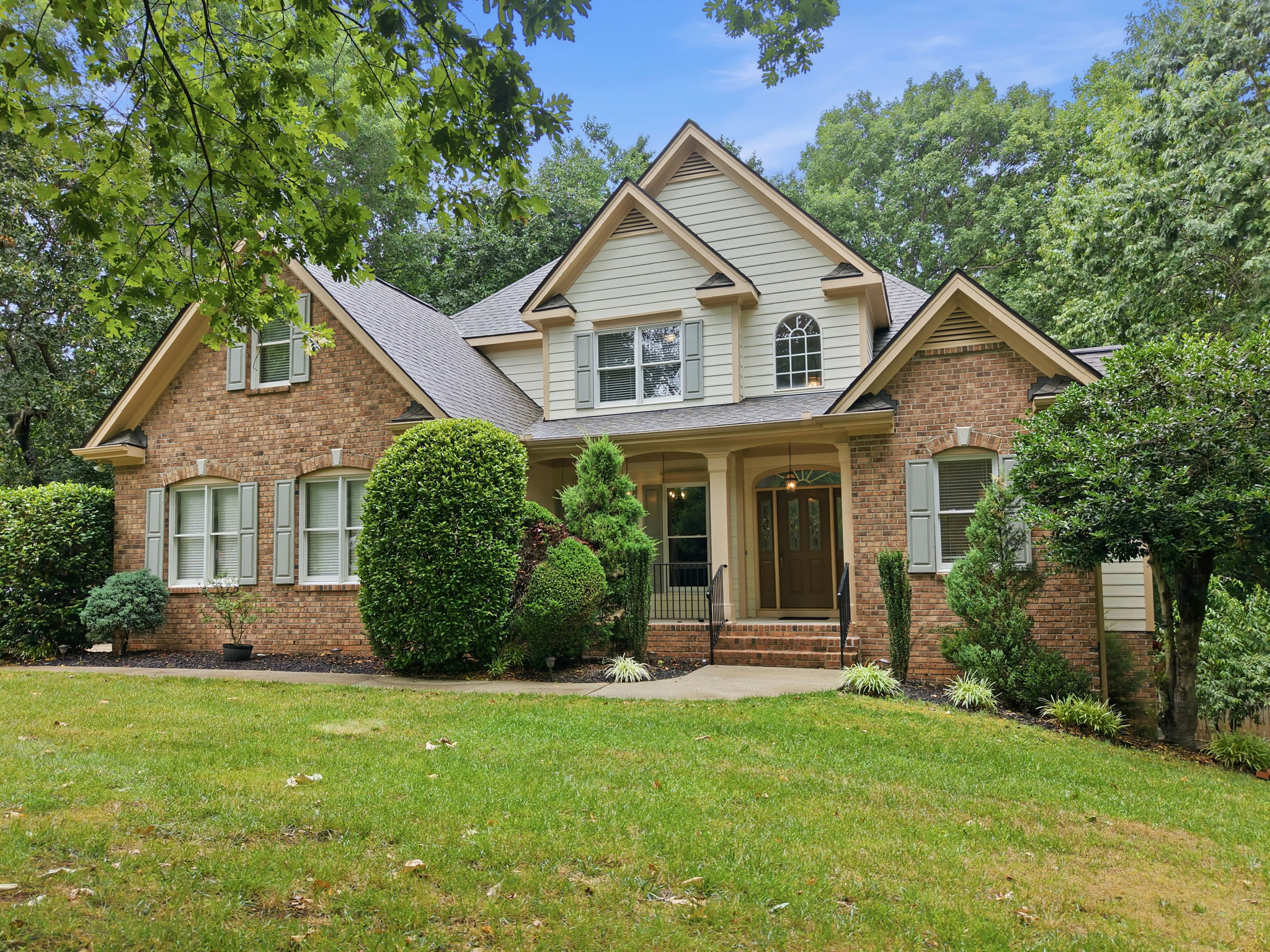 Front exterior of 155 Georgetown Woods Drive, a brick two-story home in the Georgetown Woods neighborhood of Youngsville, NC