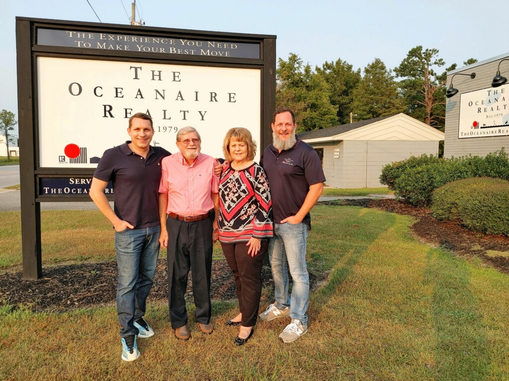 Brandon Yopp, Raleigh NC REALTOR®, with his family in front of The Oceanaire Realty office sign