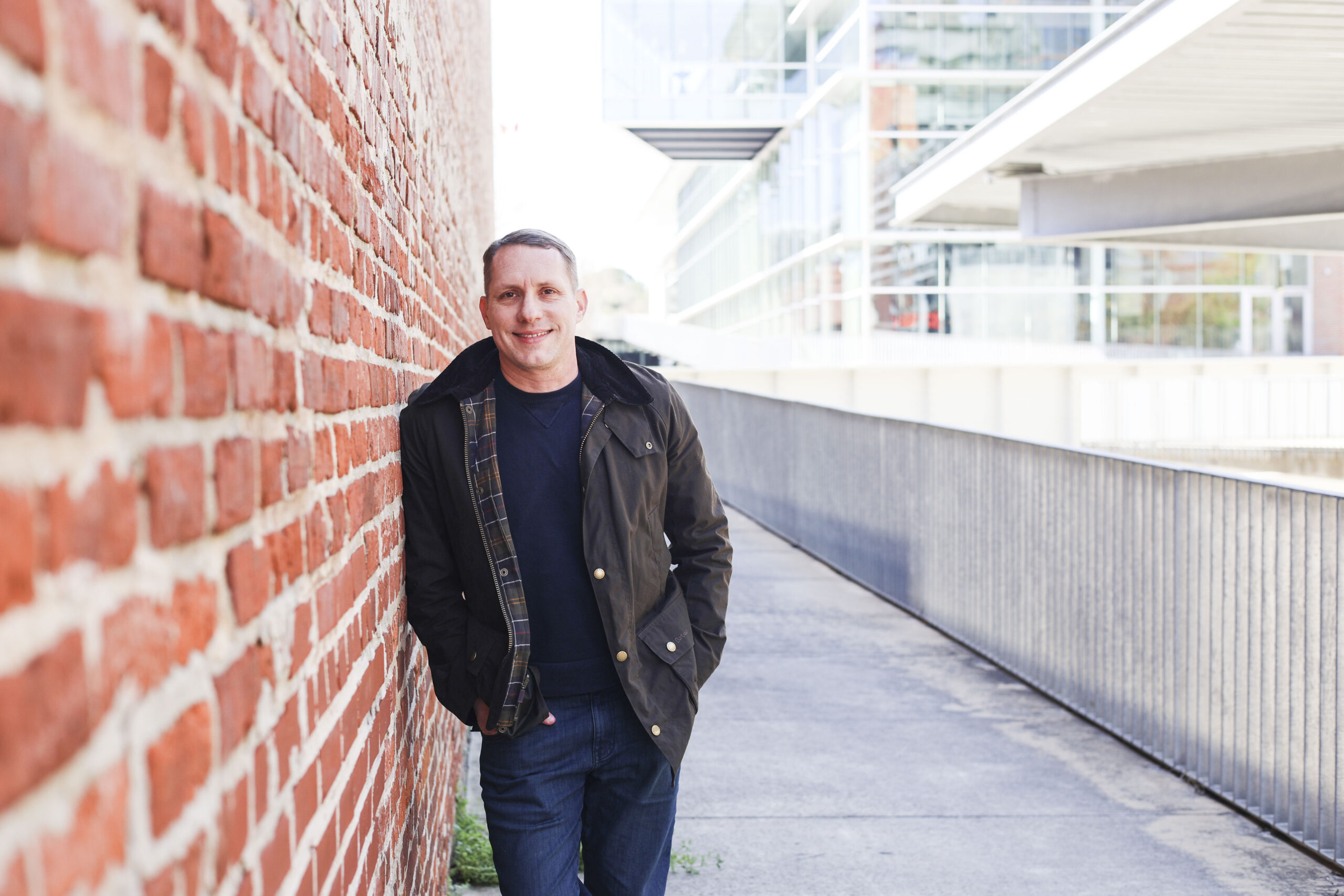 Brandon Yopp, Raleigh NC REALTOR® with The Oceanaire Realty, standing along a brick walkway in downtown Raleigh